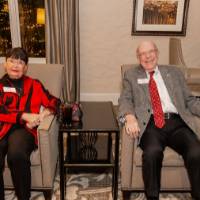 Two reception guests sitting in chairs smiling at camera